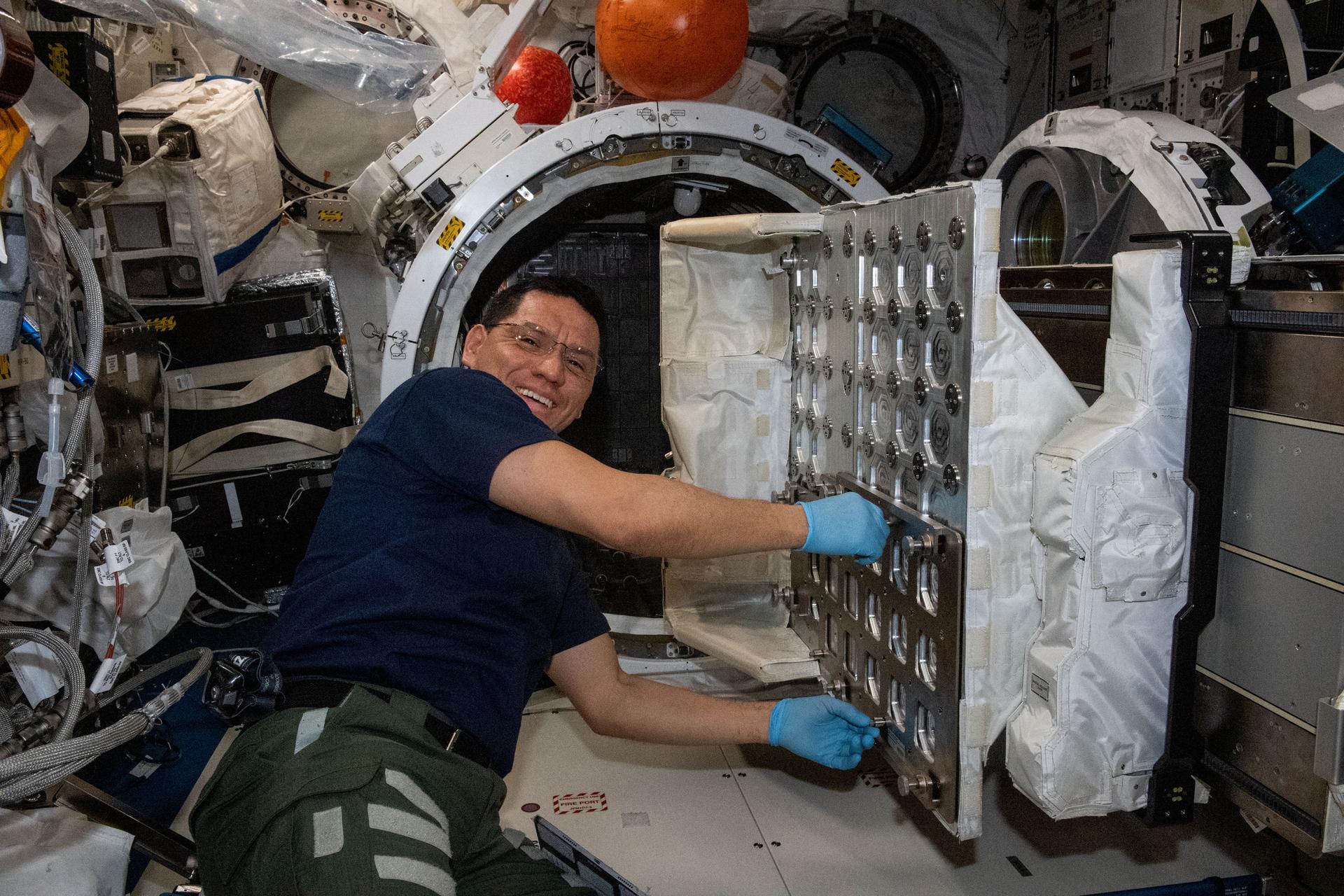 Astronaut installing NanoRacks CubeSat Deployer aboard the International Space Station